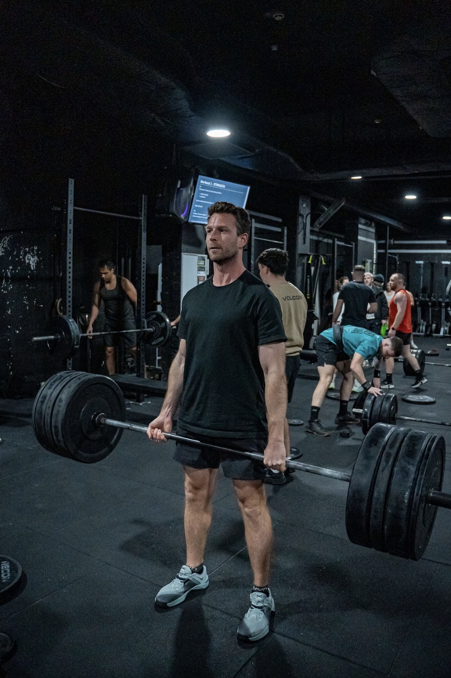 Michael at the top of a heavy deadlift at his CrossFit box